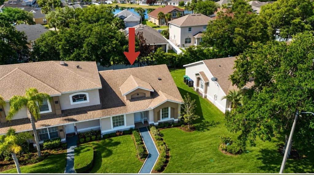 An aerial view shows the exterior of a suburban house with a red arrow pointing down — 14776 LAGUNA BEACH CIRCLE, ORLANDO, FL