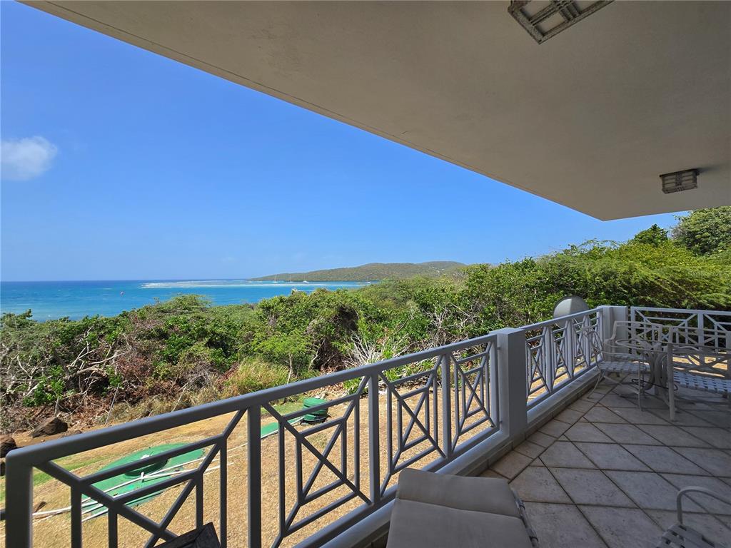 A balcony with a metal railing overlooks a coastal landscape with ocean views — Punta Canero,BO. Frailes COSTA BONITA UNIT 1702, CULEBRA, PR