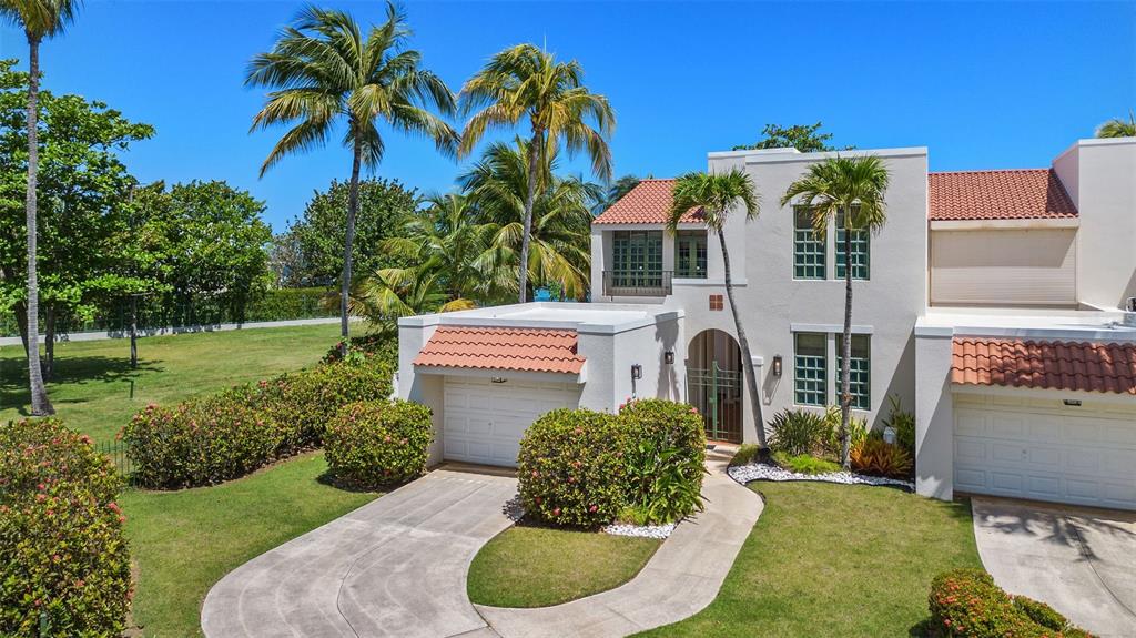 A covered patio with tiled flooring overlooks a grassy lawn and the ocean — 57 DORADO REEF, DORADO, PR