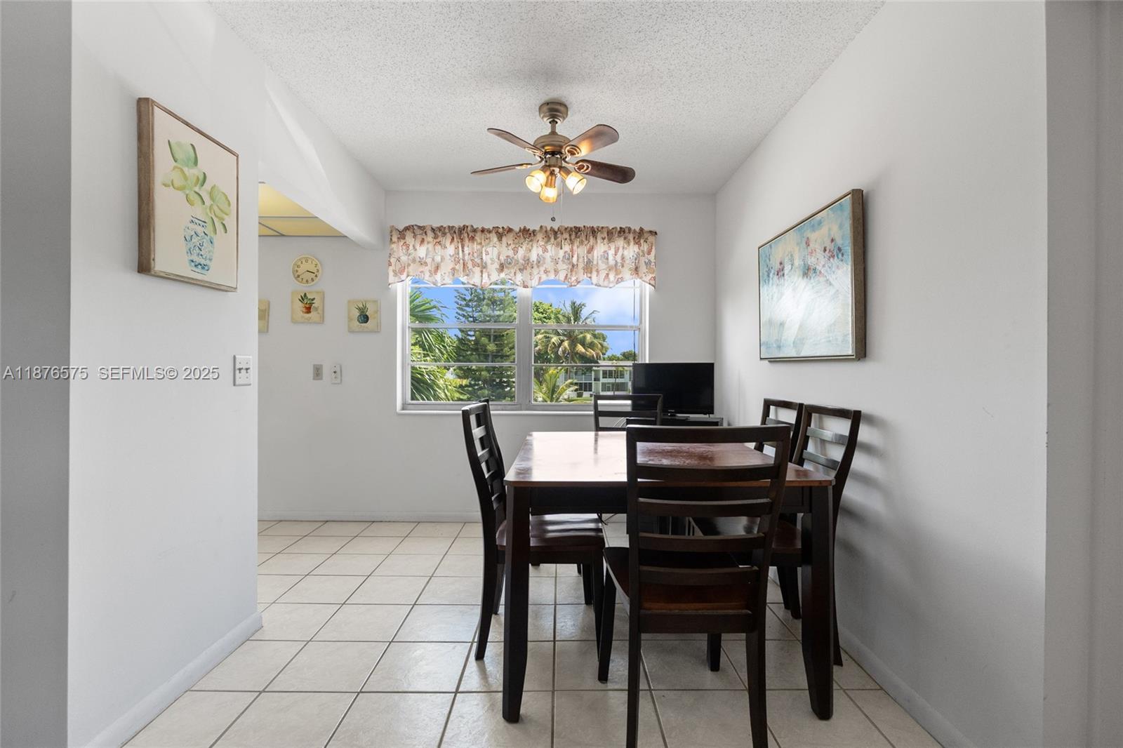 A dining room features a wooden table, four chairs, a ceiling fan, and a window — 431 Markham T # 431, Deerfield Beach FL 33442, DEERFIELD BEACH, FL