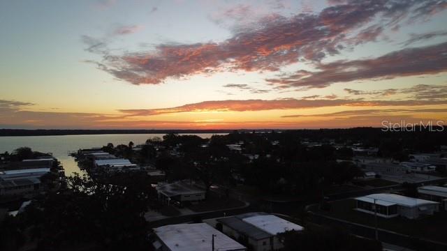 An aerial view of a residential neighborhood along a waterfront at sunset — 210 PHILADELPHIA COURT UNIT 17, PALM HARBOR, FL