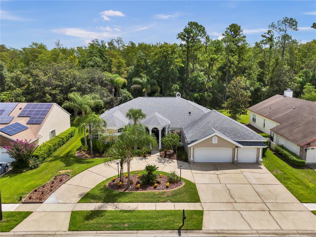 An aerial view shows a single-story house with a circular driveway and a landscaped island — 4749 SUDBURY DRIVE, ORLANDO, FL