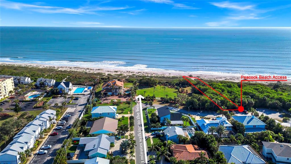 This aerial view shows a coastal neighborhood with houses, parking areas, and beach access — 363 HARBOR DR, CAPE CANAVERAL, FL