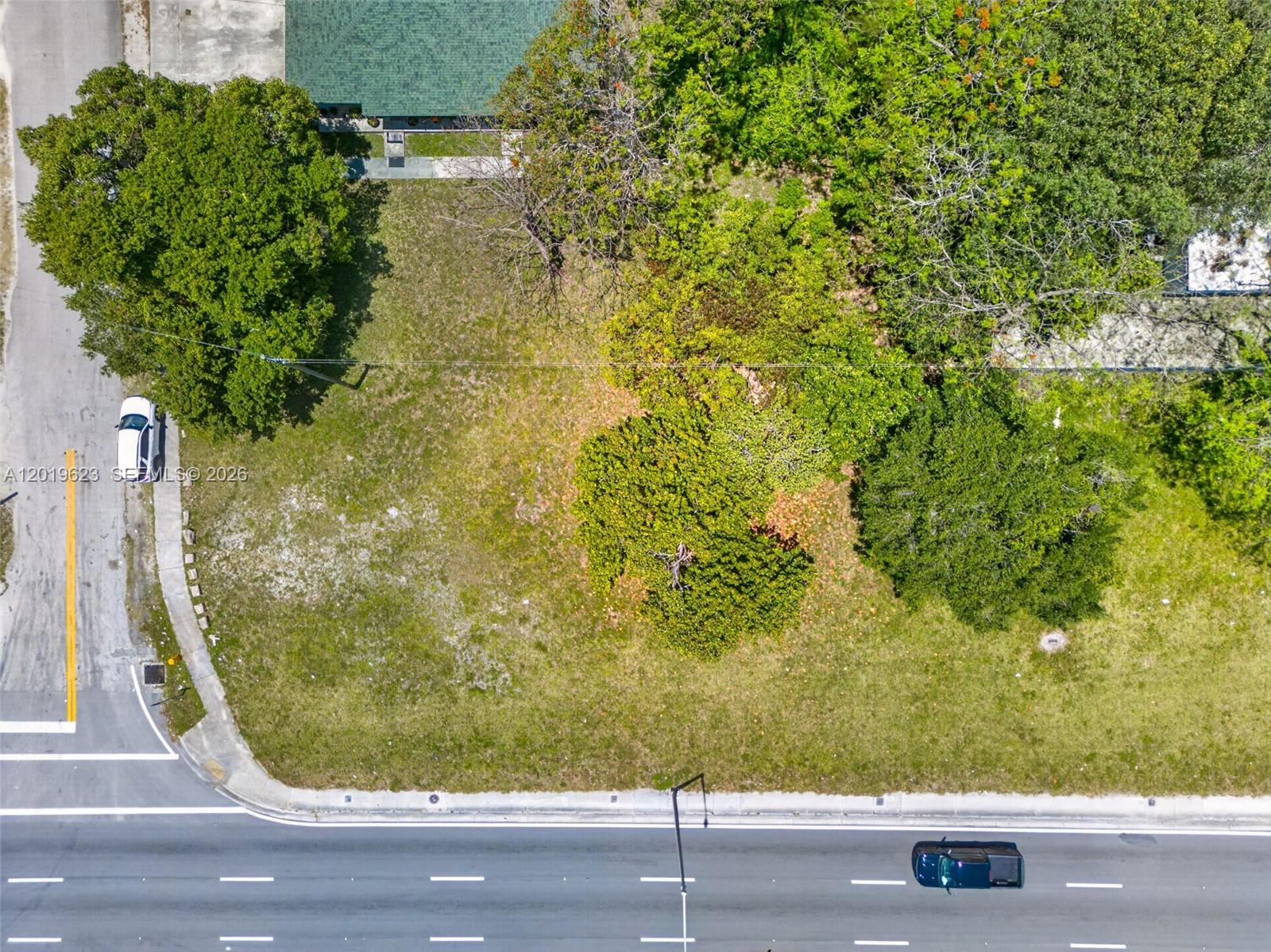 An aerial view shows a vacant, grassy lot with several trees next to a road — 63rd Miami FL 33147-0000, Miami FL 33147, MIAMI, FL
