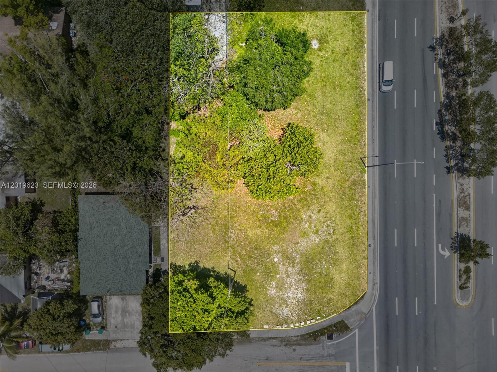 An aerial view of a vacant, tree-covered corner lot outlined in yellow next to a road — 63rd Miami FL 33147-0000, Miami FL 33147, MIAMI, FL