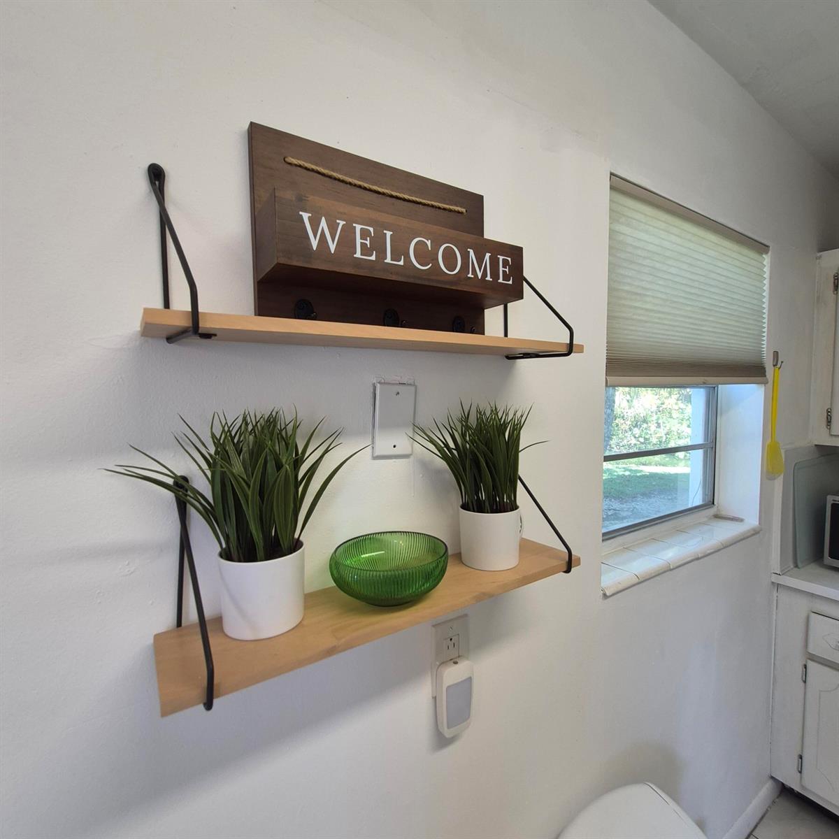Two wooden wall shelves with black metal brackets are mounted on a white kitchen wall — 101 Northampton F, West Palm Beach FL 33417, WEST PALM BEACH, FL
