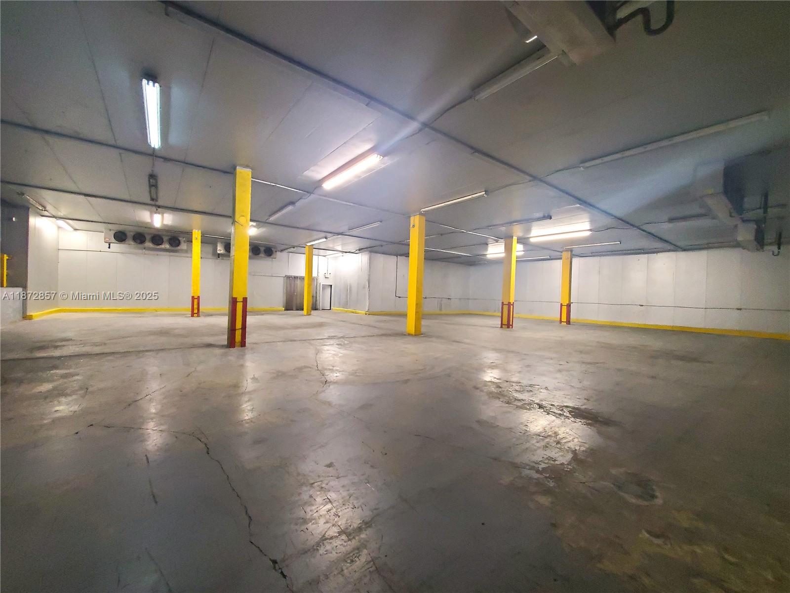 An empty industrial warehouse space features concrete floors, yellow support columns, and overhead lighting — 1395 NW 22nd St, Miami FL 33142, MIAMI, FL