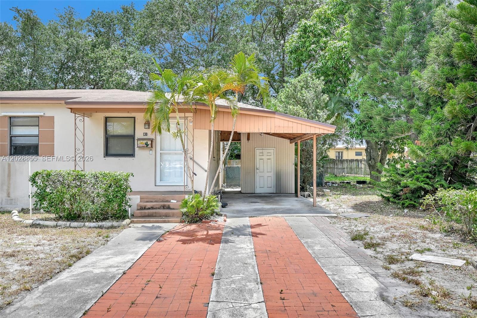A single-story house features a brick driveway, a carport, and a small front porch — 130 NE 171st Ter, Miami FL 33162, MIAMI, FL