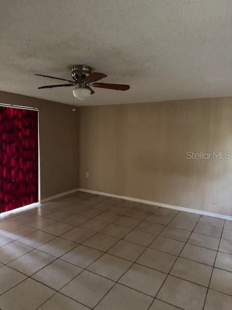 A room with beige walls, a tiled floor, and a ceiling fan — 8811 GOSHEN LANE, PORT RICHEY, FL