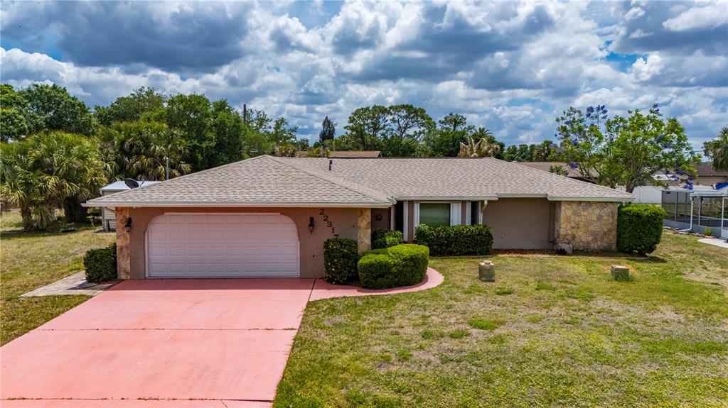 An aerial view shows a single-story house with a pool enclosure on a large lot — 22317 LAIKA AVENUE, PORT CHARLOTTE, FL
