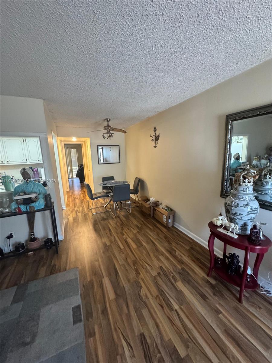A dining area with wood-look flooring, a ceiling fan, and a mirror on the wall — 142 Northampton G # 142, West Palm Beach FL 33417, WEST PALM BEACH, FL