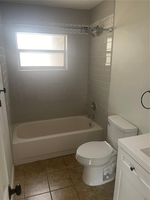 A bathroom features a tiled tub-shower combination, a white toilet, and a vanity — 906 ESSEX ROAD, BRANDON, FL