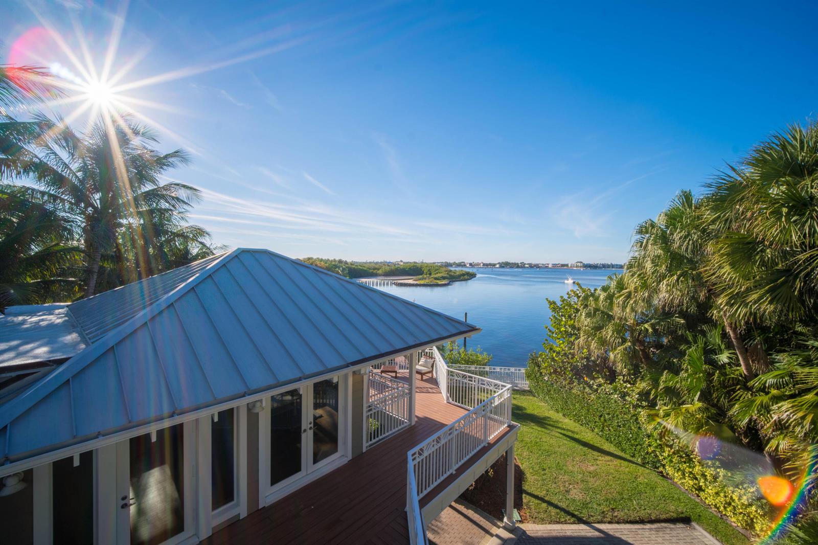 An elevated view of a house with a metal roof overlooking a calm bay — 4000 S Ocean Boulevard, Lantana FL 33462, LANTANA, FL