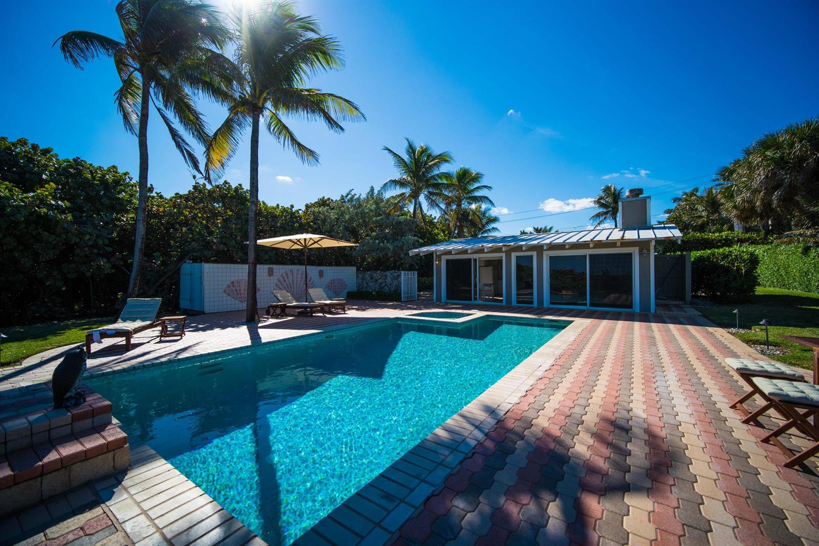 A backyard features a swimming pool, a patio with lounge chairs, and a small house — 4000 S Ocean Boulevard, Lantana FL 33462, LANTANA, FL