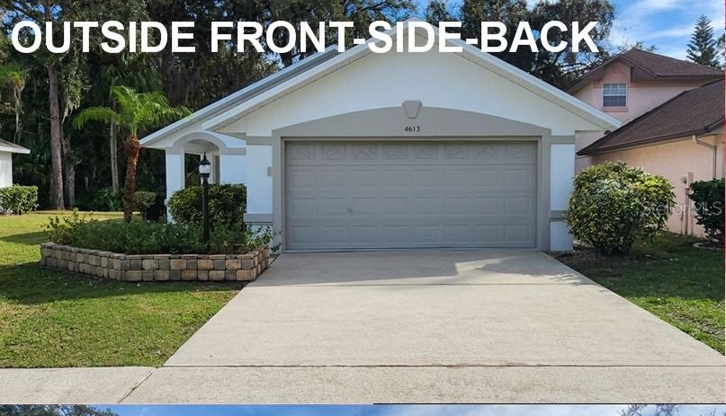 The exterior of a single-story house features a two-car garage and a stone-bordered garden bed — 4613 BARNACLE DRIVE, PORT ORANGE, FL