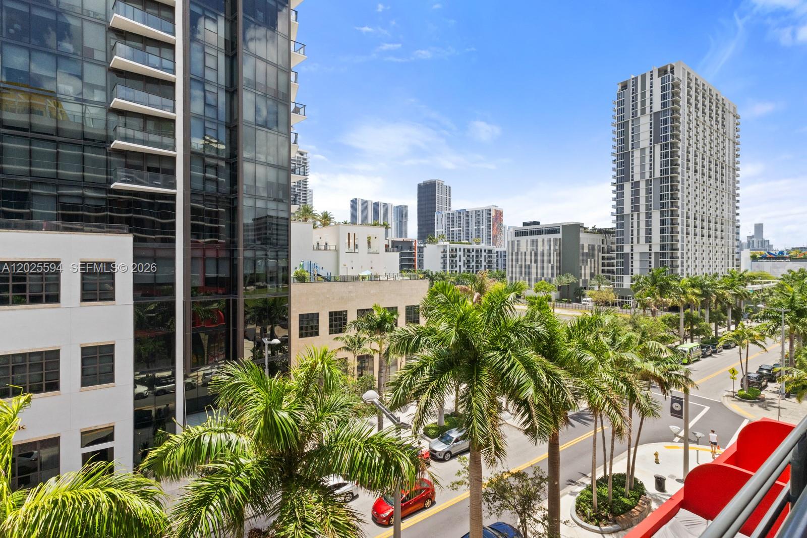An elevated view of a city street lined with palm trees and modern high-rise buildings — 90 NE 32ND ST # 506, Miami FL 33137, MIAMI, FL