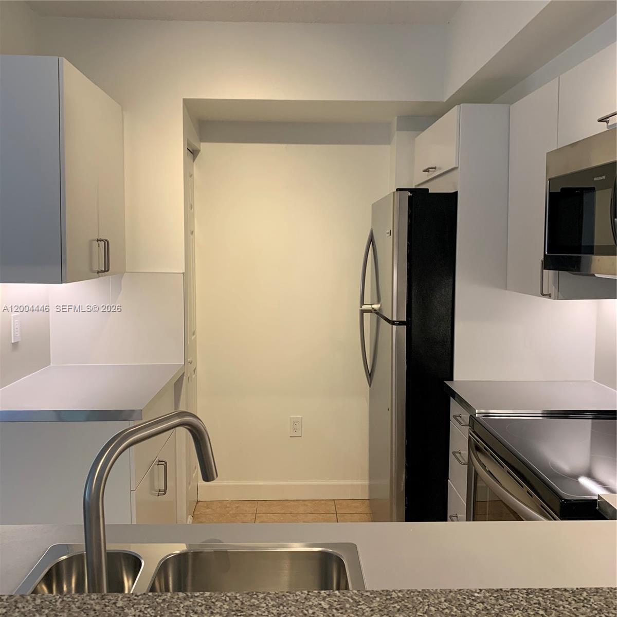 A kitchen features white cabinetry, stainless steel appliances, and a double-basin sink — 2200 E Preserve Way # 301, Miramar FL 33025, MIRAMAR, FL