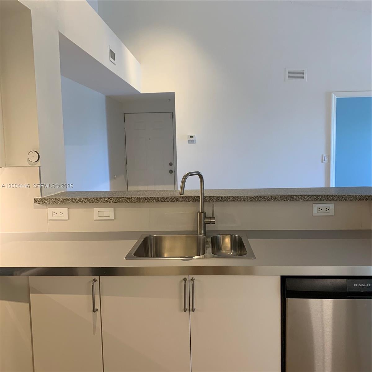 A kitchen sink with a stainless steel faucet sits in a counter with white cabinets — 2200 E Preserve Way # 301, Miramar FL 33025, MIRAMAR, FL