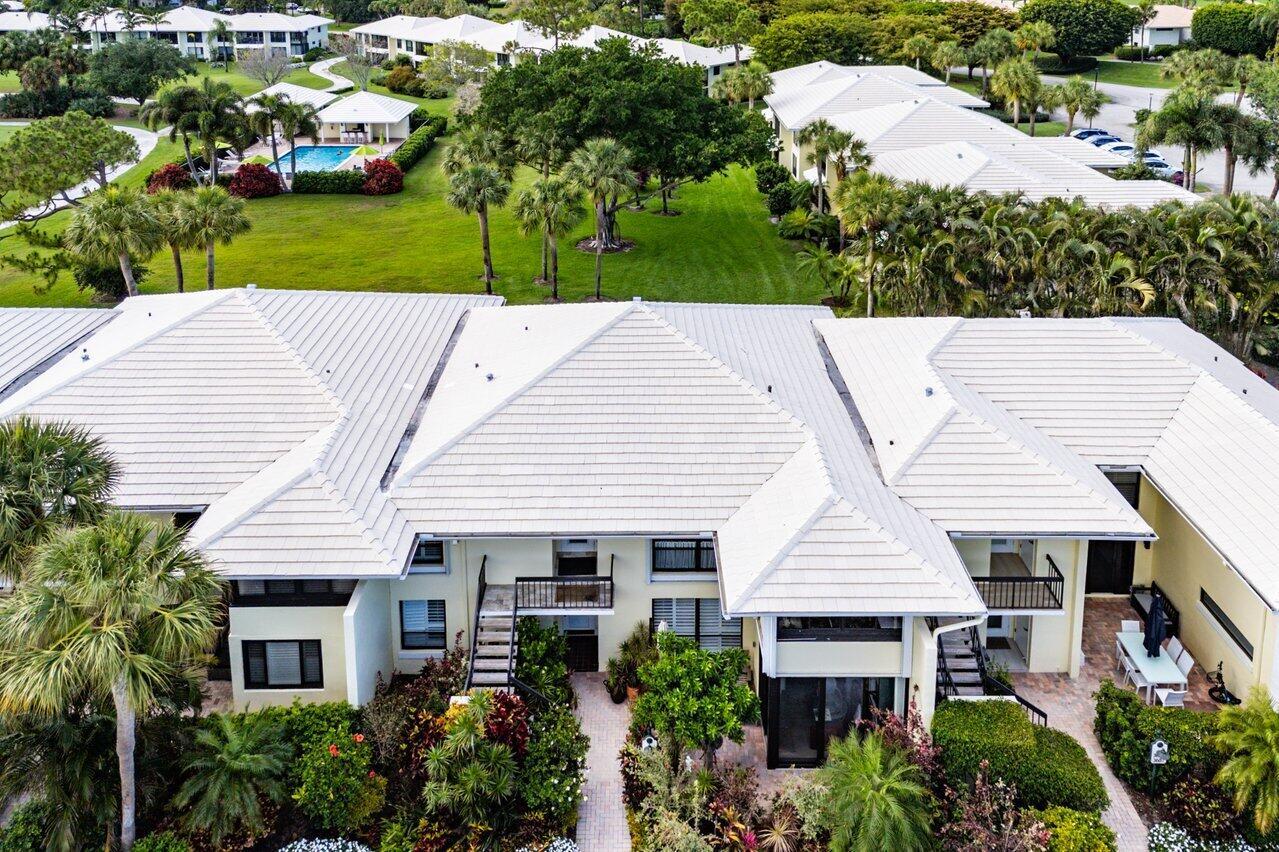 An aerial view of a multi-unit residential building with a white metal roof and landscaping — 3677 Quail Ridge Drive # B, Boynton Beach FL 33436, BOYNTON BEACH, FL