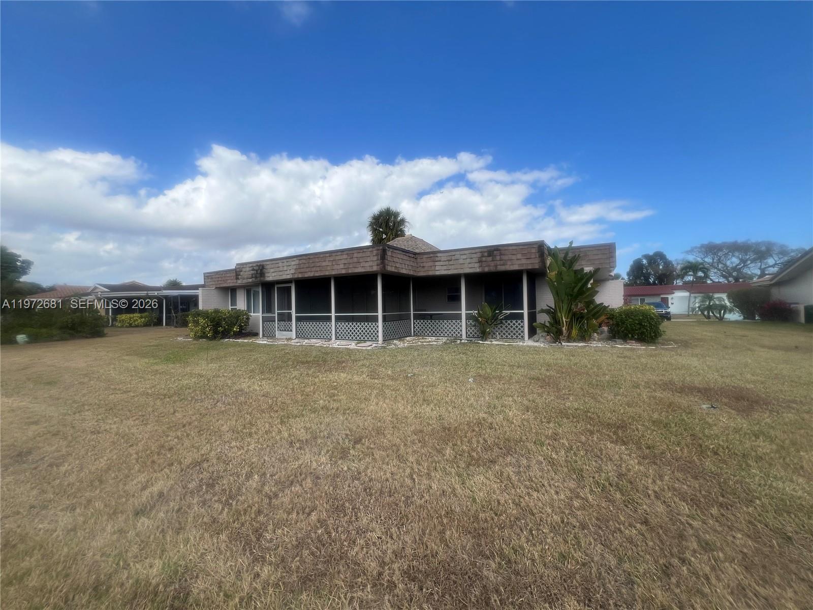 A single-story house features a large screened-in porch and a brown shingled roof — 5724 S Bayberry Ln, Tamarac FL 33319, TAMARAC, FL