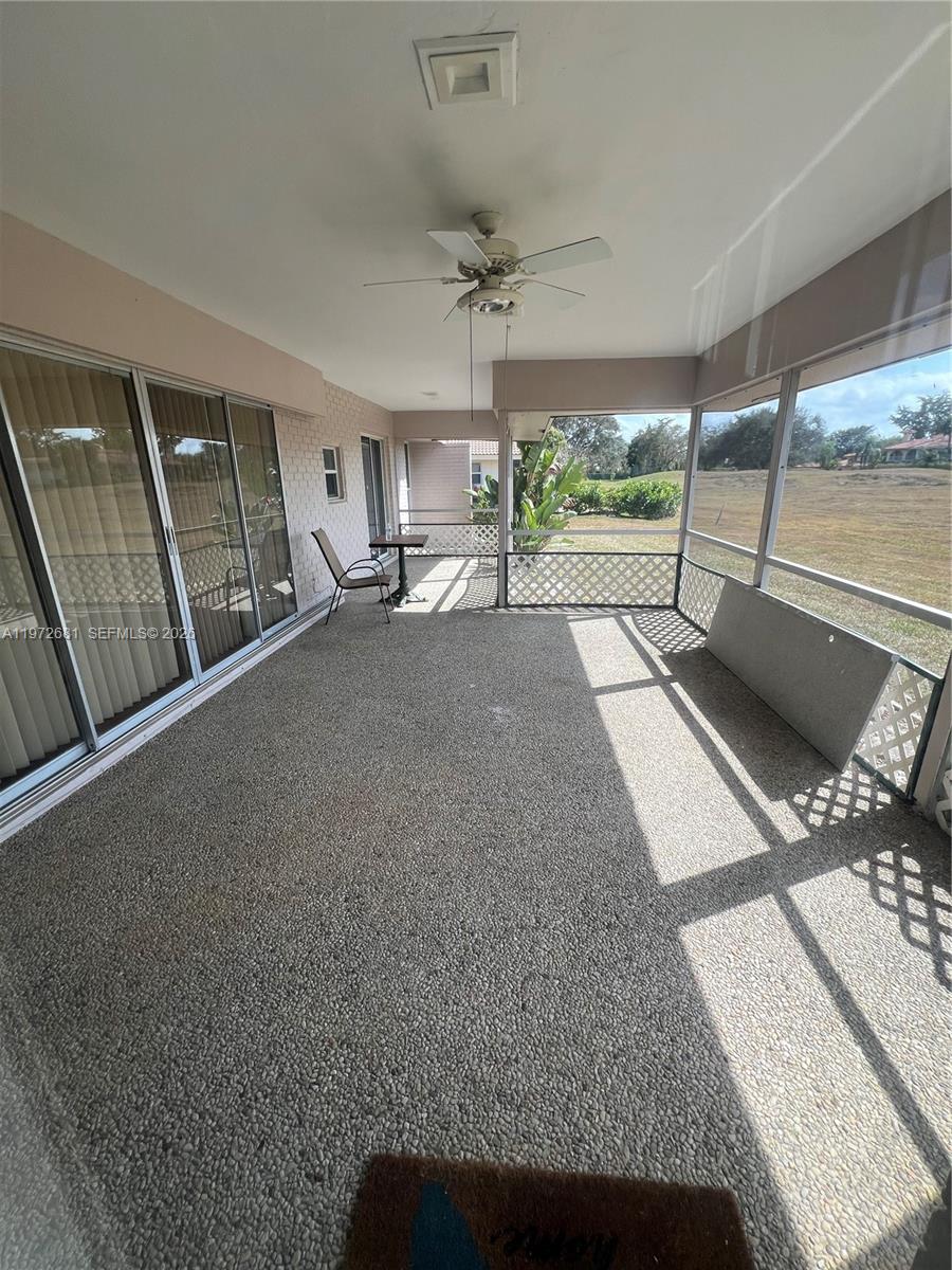 A covered patio features a textured concrete floor, a ceiling fan, and screened-in walls — 5724 S Bayberry Ln, Tamarac FL 33319, TAMARAC, FL