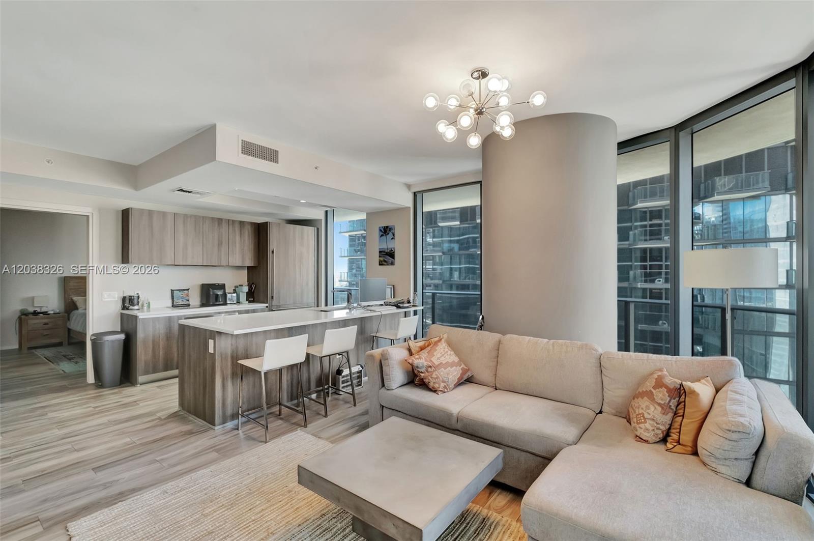 A modern open-concept living room and kitchen featuring a sectional sofa and breakfast bar — 801 S Miami Ave # 2205, Miami FL 33130, MIAMI, FL