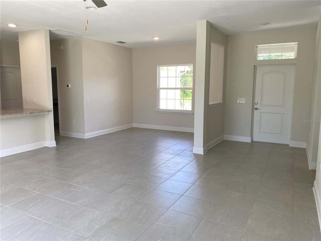 An open-concept living area features light gray tile flooring, neutral walls, and a front entryway — 3467 INVERNESS STREET, NORTH PORT, FL