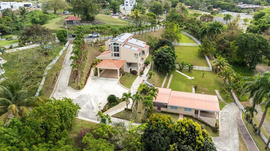 An aerial view shows a multi-story house with solar panels and a separate smaller building — 23 & 24 HACIENDA CARABALI, LUQUILLO, PR