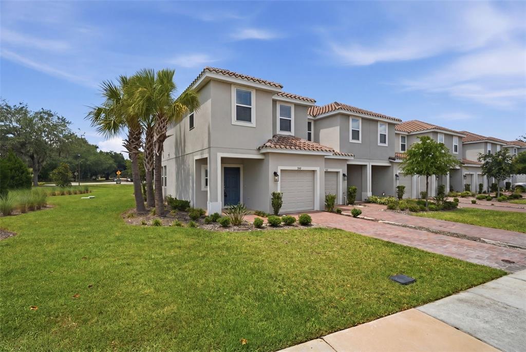A two-story townhouse with a beige stucco exterior, a tile roof, and a paved driveway — 3684 CIRCLE HOOK STREET, KISSIMMEE, FL