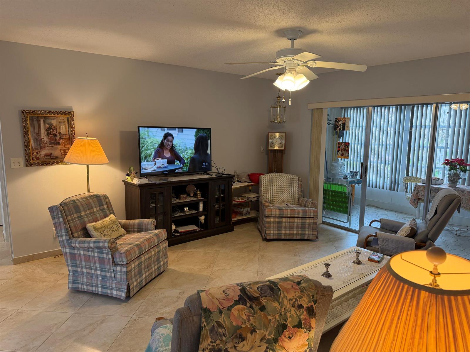 A living room with tile floors, a ceiling fan, multiple armchairs, and a television console — 701 Lori Drive # 204, Palm Springs FL 33461, PALM SPRINGS, FL
