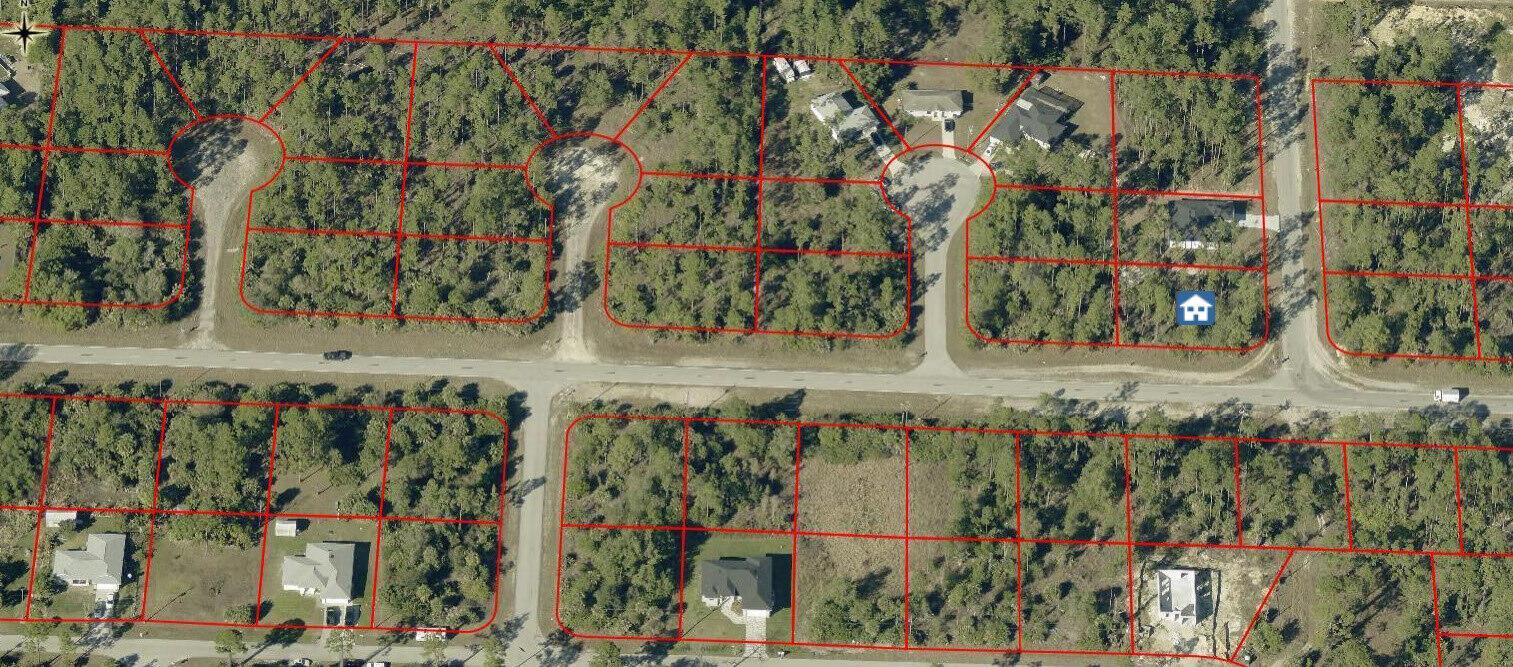 An aerial view shows a residential neighborhood with several houses on wooded lots and roads — 107 Moore Avenue, Lehigh Acres FL 33936, LEHIGH ACRES, FL