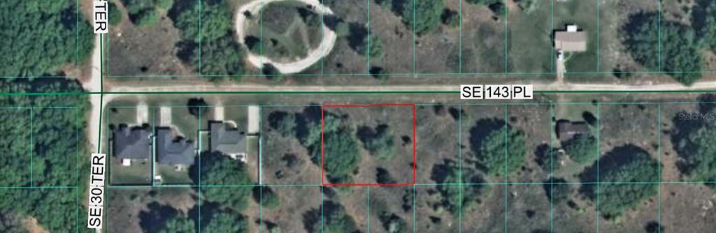 This is an aerial map view showing a vacant rectangular lot outlined in red — TBD SE 143RD PLACE, SUMMERFIELD, FL