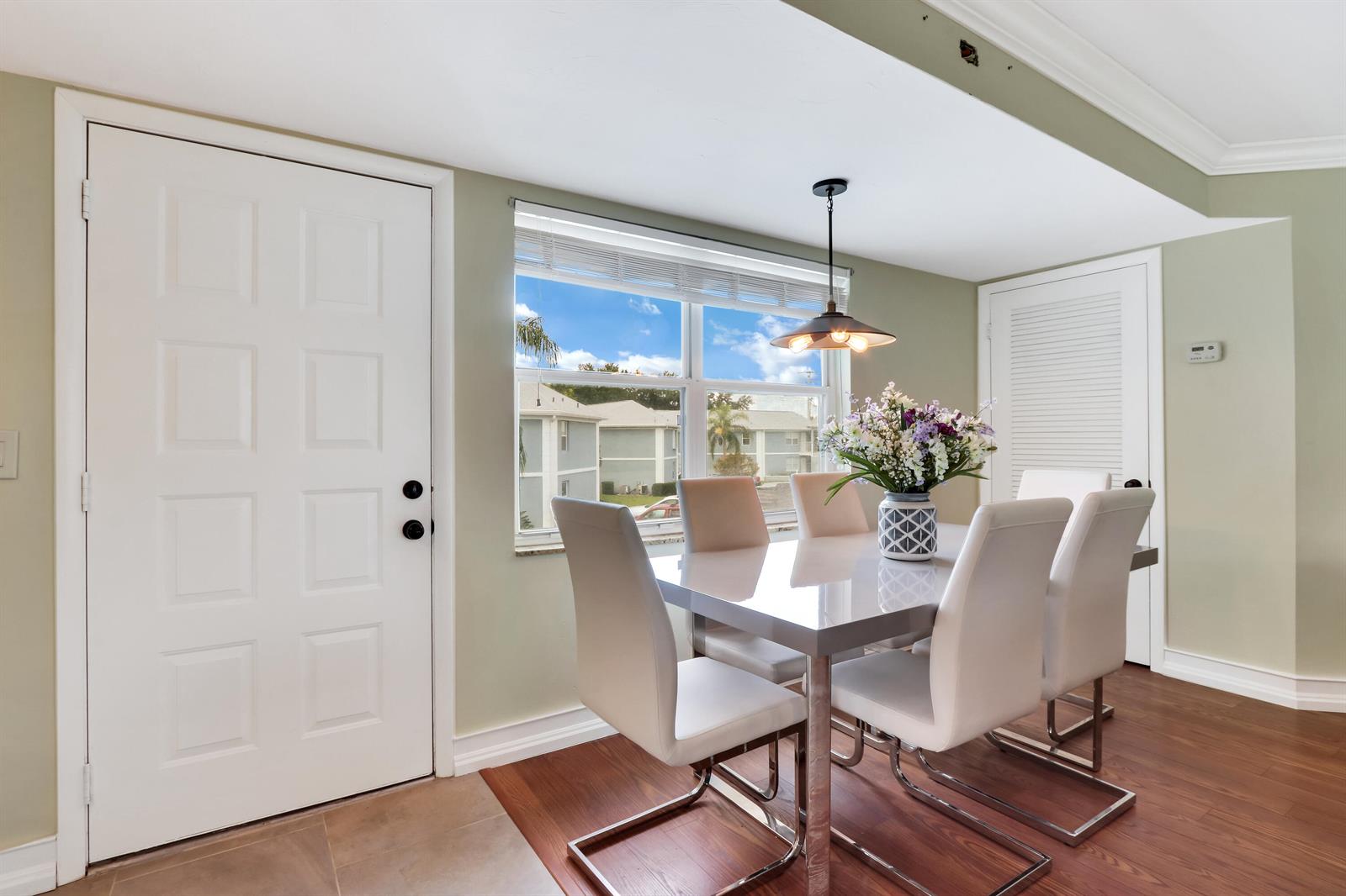 A dining area features a white table with six chairs, a pendant light, and windows — 3296 SE Aster Lane, Stuart FL 34994, STUART, FL