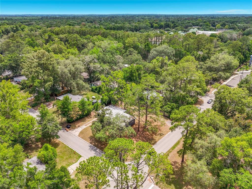 An aerial view shows a house surrounded by trees in a suburban neighborhood — 414 NW 36TH TERRACE, GAINESVILLE, FL
