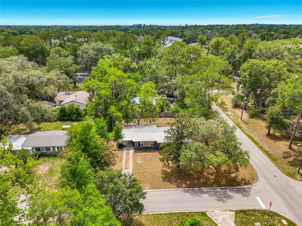 An aerial view shows a single-story house with a metal roof and a large yard — 414 NW 36TH TERRACE, GAINESVILLE, FL