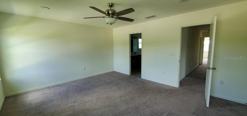 A kitchen features dark wood cabinets, stainless steel appliances, white countertops, and patterned tile flooring — 2354 TWIN FLOWER LANE, SANFORD, FL