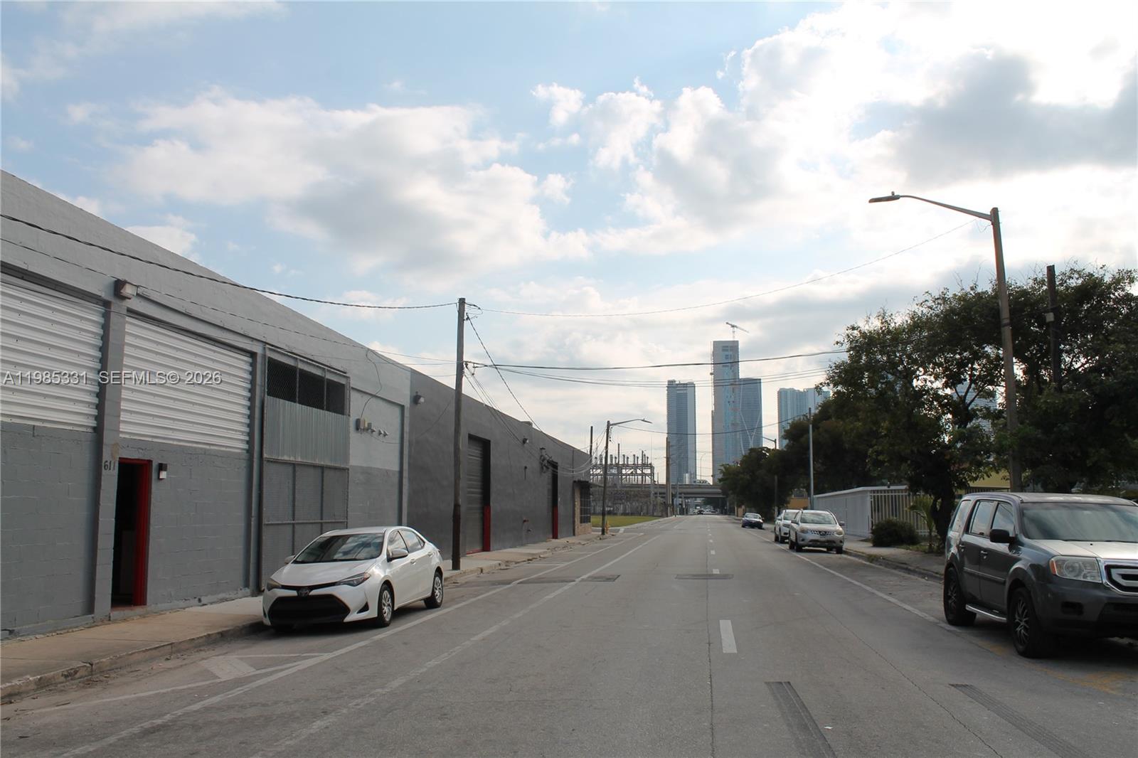 A street view shows a gray industrial building on the left and parked cars — 611 NW 11th St, Miami FL 33136, MIAMI, FL