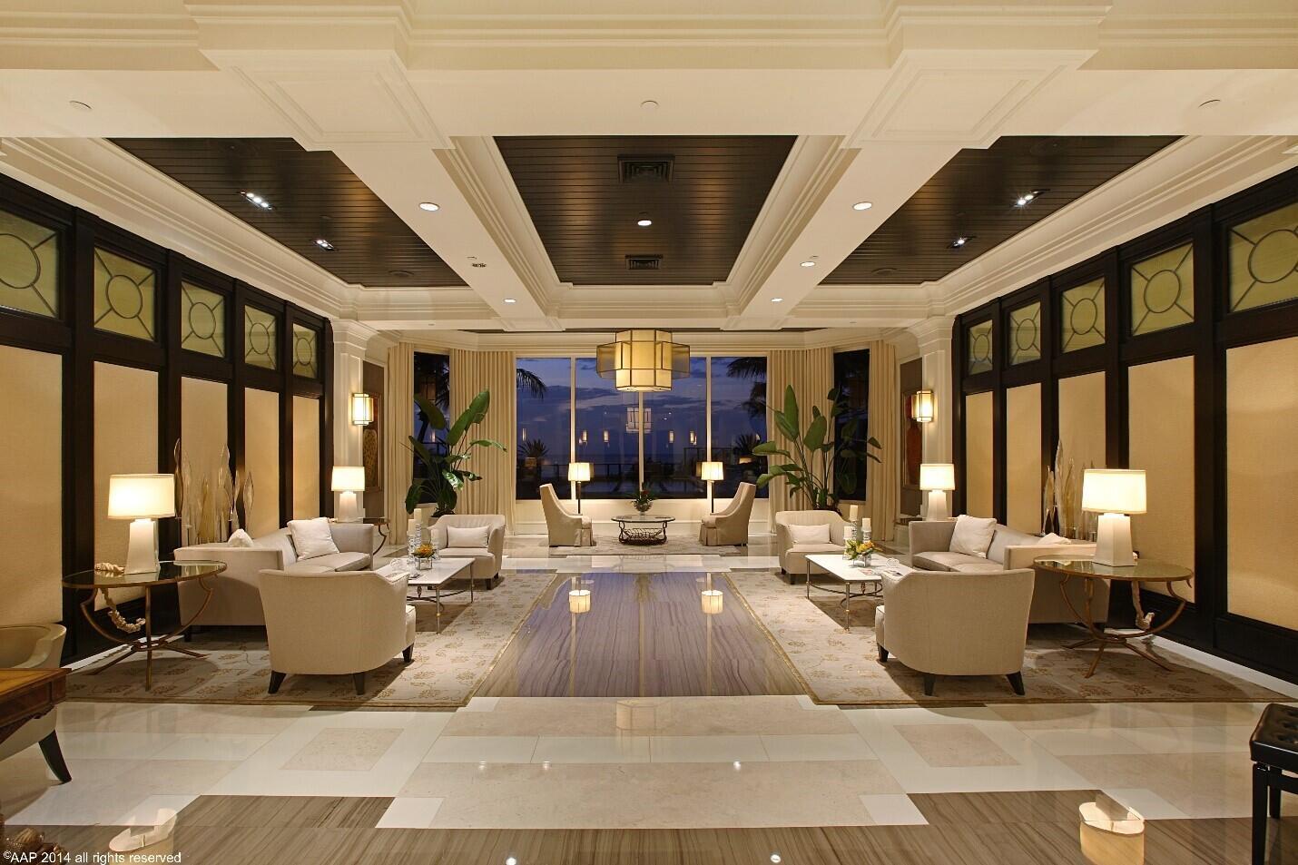 A symmetrical, upscale hotel lobby features dark wood ceilings, cream-colored seating, and floor-to-ceiling windows — 2700 N Ocean Drive # 2003b, Singer Island FL 33404, SINGER ISLAND, FL