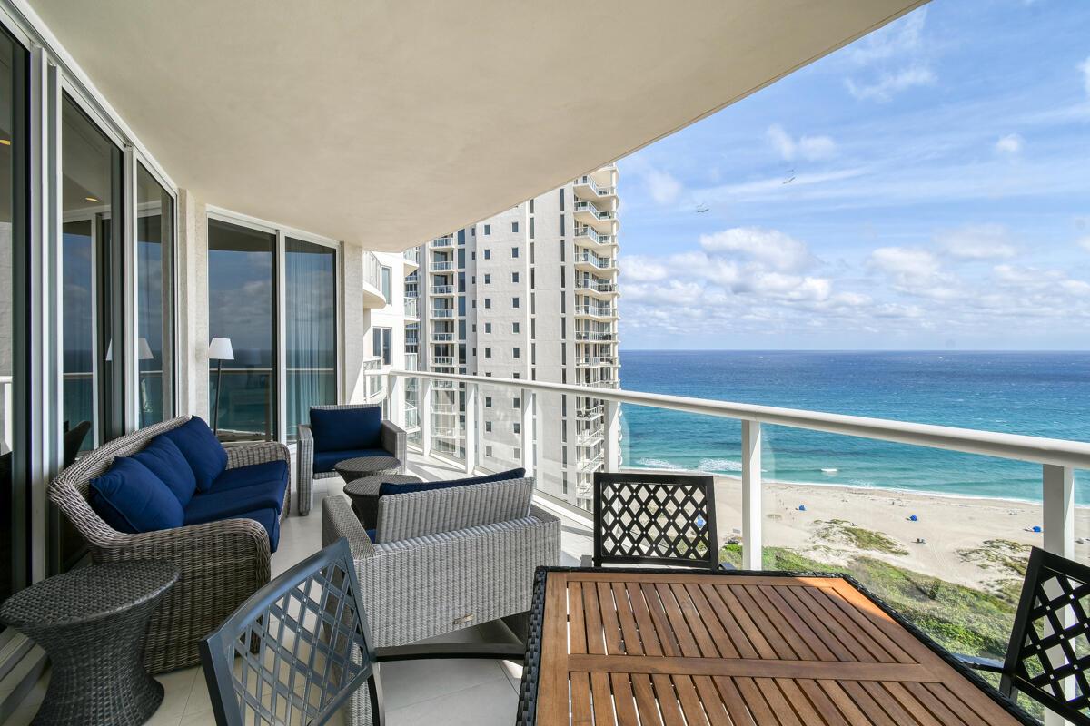 A balcony with outdoor furniture overlooks the beach and ocean from a high-rise building — 2700 N Ocean Drive # 2003b, Singer Island FL 33404, SINGER ISLAND, FL