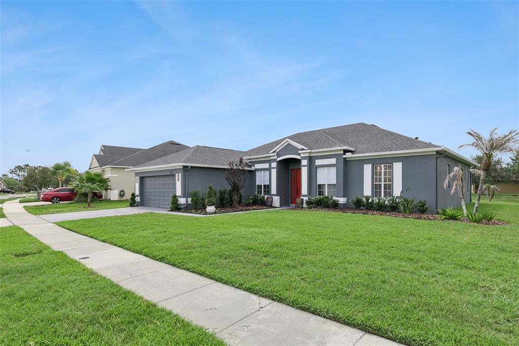 A gray single-story house with a red front door and a two-car garage — 13606 SUMMER RAIN DRIVE, ORLANDO, FL