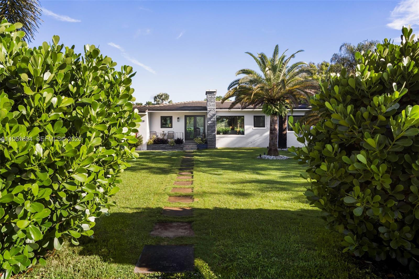A single-story house with a stone chimney and a stone path through the front lawn — 07325 SW 102nd St, Pinecrest FL 33156, PINECREST, FL