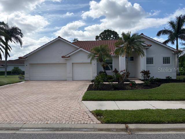 A single-story house with a tiled roof, two-car garage, and a paved driveway — 8753 MERION AVENUE, SARASOTA, FL