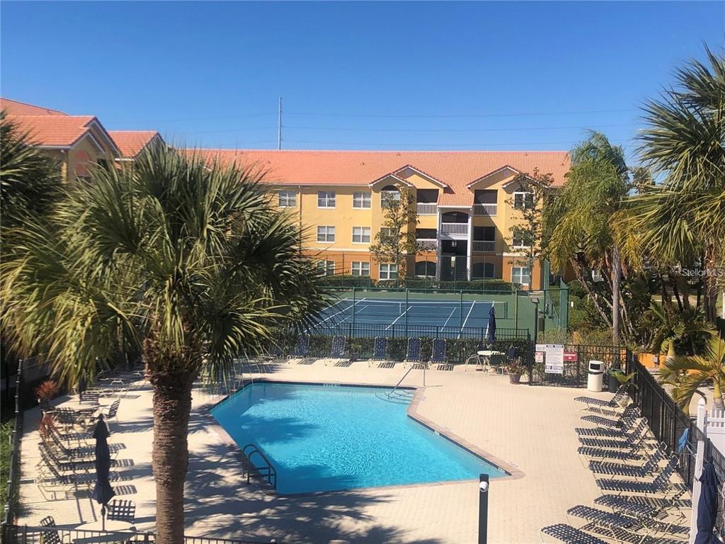 An outdoor swimming pool and tennis court are located in front of a multi-story apartment building — 10764 70TH AVENUE UNIT 3207, SEMINOLE, FL