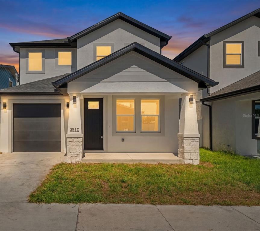 A two-story house with a white stucco exterior, a front porch, and a single-car garage — 2910 N 21ST STREET, TAMPA, FL