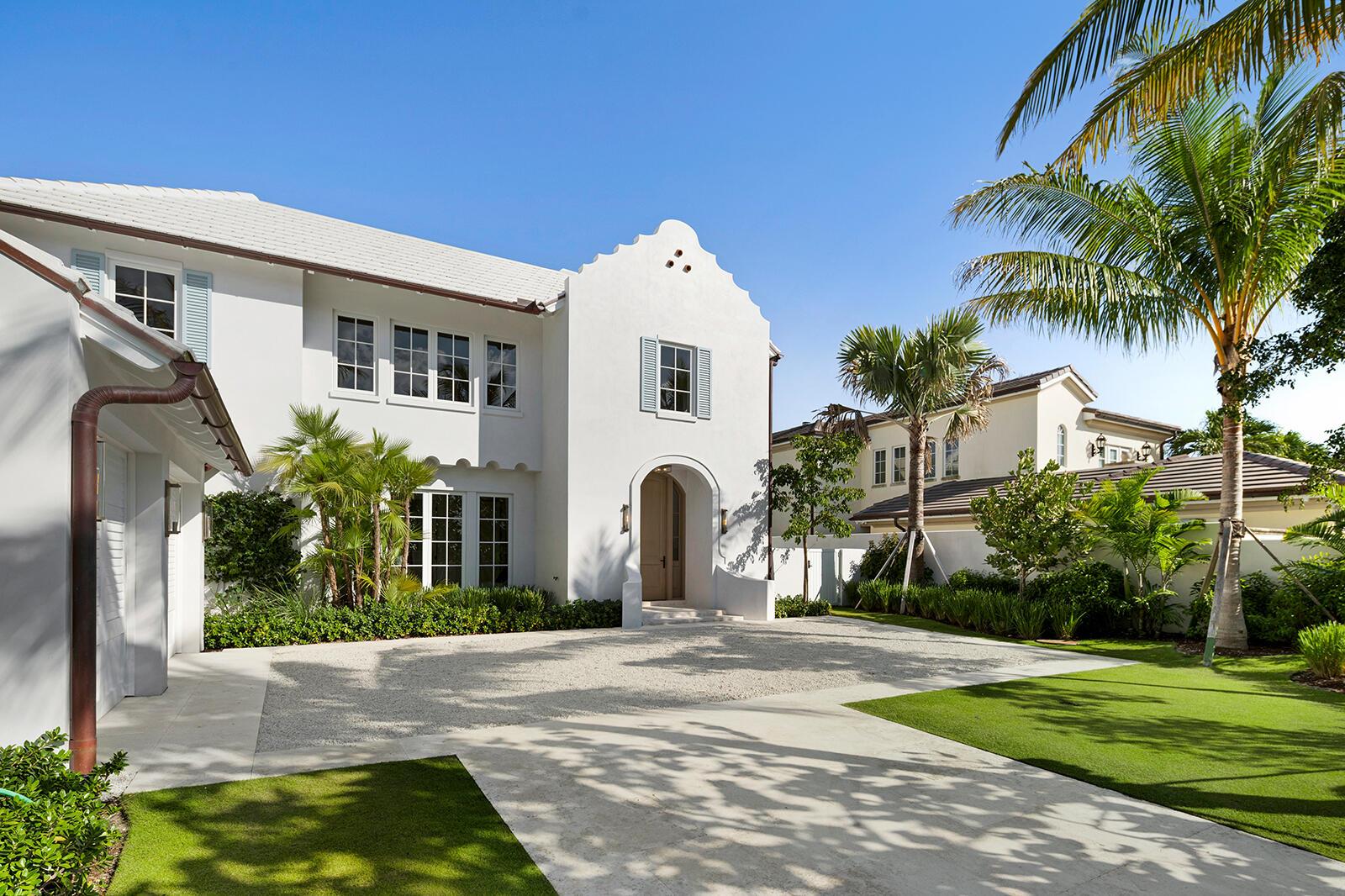 A white two-story house with a gravel driveway, arched entryway, and palm trees — 2219 Ibis Isle Road E, Palm Beach FL 33480, PALM BEACH, FL