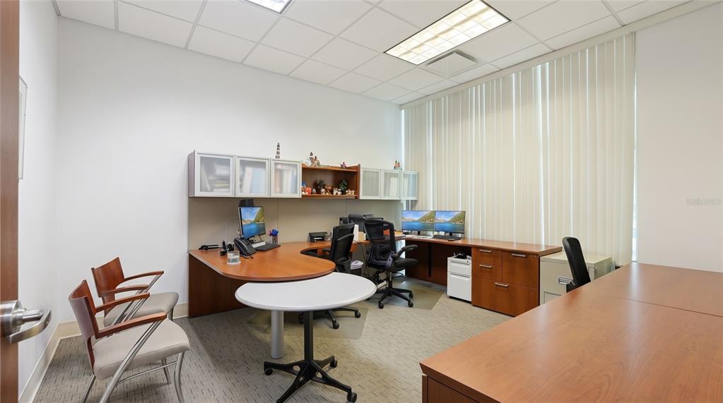 An office features a wooden desk, two guest chairs, and a large window with blinds — 10967 LAKE UNDERHILL ROAD UNIT 112, ORLANDO, FL