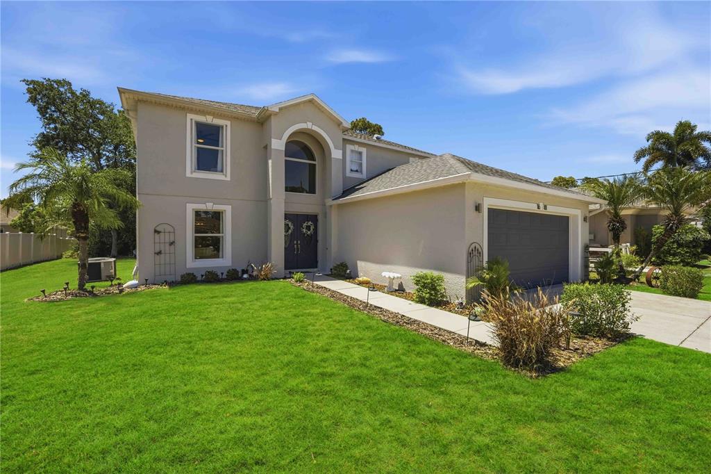 A two-story house with a gray exterior, a front-facing garage, and a manicured lawn — 1681 DAWNVIEW STREET, NORTH PORT, FL