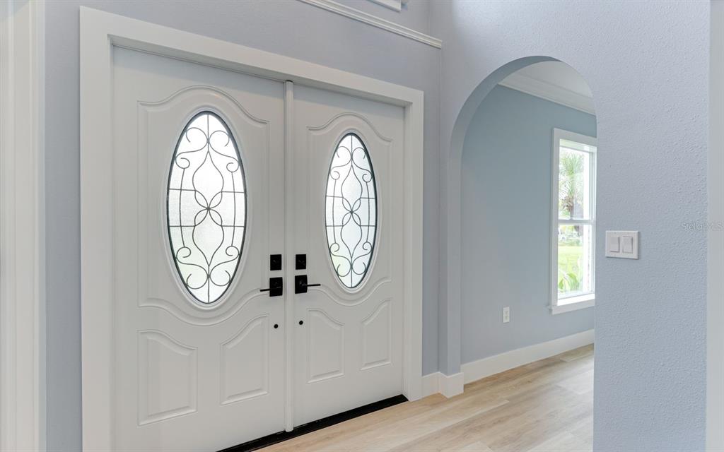 A white double front door with oval glass inserts opens into a light blue foyer — 1681 DAWNVIEW STREET, NORTH PORT, FL