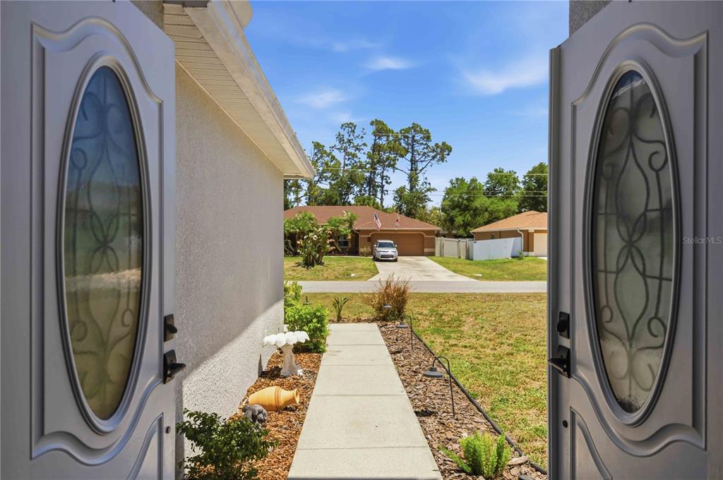 A view from an open double front door looking out toward a suburban street — 1681 DAWNVIEW STREET, NORTH PORT, FL