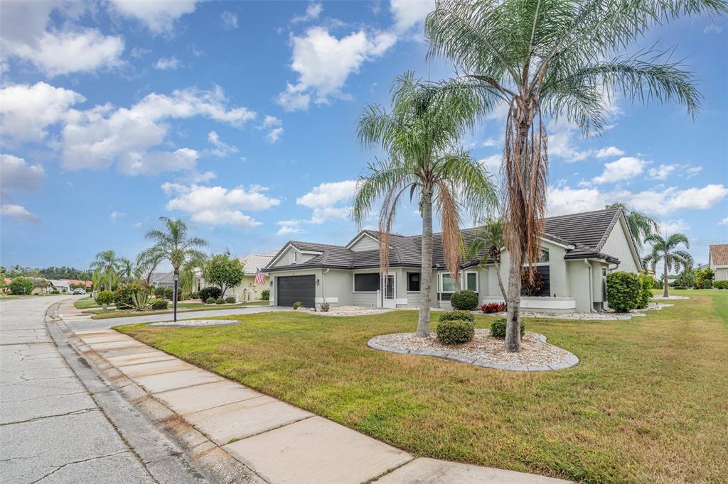 A single-story suburban house with a dark roof, light exterior, and palm trees in front — 2048 BERRY ROBERTS DRIVE, SUN CITY CENTER, FL